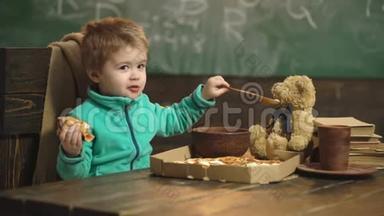 在木制背景下吃披萨的男孩。 美味的披萨。 小男孩在吃披萨。 营养概念。 男孩